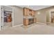View of the basement wet bar, featuring wooden cabinets, tiled backsplash, wine rack, and stainless steel dishwasher at 570 Stonemont Dr, Castle Pines, CO 80108