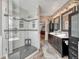 Elegant bathroom featuring a glass shower with seat and double vanity with decorative mirrors and fixtures at 570 Stonemont Dr, Castle Pines, CO 80108