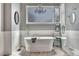 Elegant bathroom with a freestanding tub, a chandelier, wainscoting, and a glass-enclosed shower at 570 Stonemont Dr, Castle Pines, CO 80108