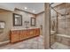 Spacious bathroom with double sinks, tiled floor, and tiled shower with glass door and bench at 570 Stonemont Dr, Castle Pines, CO 80108