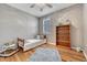 Bright bedroom features a twin bed, shuttered window, wood floors, bookshelf, and neutral decor at 570 Stonemont Dr, Castle Pines, CO 80108