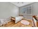 Cozy bedroom features a twin bed, shuttered window, wood floors, rocking chair, and a piano at 570 Stonemont Dr, Castle Pines, CO 80108