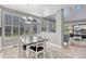 Light-filled dining room with contemporary table set and backyard view through many windows at 570 Stonemont Dr, Castle Pines, CO 80108