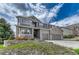 Beautiful two-story home with a gray exterior, brick accents, a well-maintained lawn, and a two-car garage at 570 Stonemont Dr, Castle Pines, CO 80108