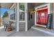 Inviting front porch featuring a red door, gray siding, a cozy bench, and a 'Welcome' sign at 570 Stonemont Dr, Castle Pines, CO 80108