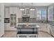 Modern kitchen with white cabinets, stainless steel appliances, granite counters, and a central island with seating at 570 Stonemont Dr, Castle Pines, CO 80108