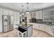 Bright kitchen with stainless steel fridge, black granite countertops, and island seating at 570 Stonemont Dr, Castle Pines, CO 80108