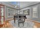 A piano and bench sit in the corner of this well-lit room with hardwood floors and plantation shutters at 570 Stonemont Dr, Castle Pines, CO 80108
