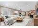 Spacious finished basement with a large white sectional couch, a round wooden coffee table, and a dining area at 570 Stonemont Dr, Castle Pines, CO 80108