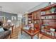 Comfortable living room features a large bookshelf, hardwood floors, a table with books and a leather chair at 570 Stonemont Dr, Castle Pines, CO 80108