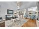Open-concept living room with hardwood floors, a gray leather sofa, and views into the foyer and kitchen at 570 Stonemont Dr, Castle Pines, CO 80108