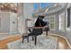 Grand living room features a grand piano with high ceilings and shuttered windows at 570 Stonemont Dr, Castle Pines, CO 80108
