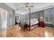 Light and airy primary bedroom features hardwood floors, sitting area, four poster bed, and a ceiling fan at 570 Stonemont Dr, Castle Pines, CO 80108