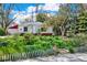 Quaint home with a landscaped front yard featuring lush greenery and a cozy detached garage at 5211 Dover St, Arvada, CO 80002