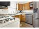 Bright kitchen featuring stainless steel appliances, countertop and wooden cabinets at 5211 Dover St, Arvada, CO 80002
