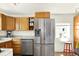 Bright kitchen featuring stainless steel refrigerator and wooden cabinetry at 5211 Dover St, Arvada, CO 80002