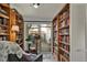 Cozy home library featuring floor-to-ceiling bookshelves, comfortable seating, and natural light from sliding glass doors at 5211 Dover St, Arvada, CO 80002