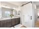 Stylish bathroom with double sinks, a sliding barn door, and ample cabinet space at 8582 Cheraw St, Littleton, CO 80125