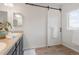 Bathroom with dual sinks, white sliding barn door, and wood-look flooring at 8582 Cheraw St, Littleton, CO 80125