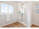 Bright bathroom featuring a glass-enclosed shower, light wood flooring, and a large window for natural light at 8582 Cheraw St, Littleton, CO 80125
