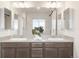 Bathroom featuring double sinks, spacious vanity, and well-lit mirror, creating a functional space at 8582 Cheraw St, Littleton, CO 80125