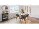 Cozy dining area with a round glass table, seating for four, and a view of the landscaped backyard at 8582 Cheraw St, Littleton, CO 80125