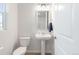 Neat powder room with a pedestal sink, a toilet, and a window offering natural light at 8582 Cheraw St, Littleton, CO 80125