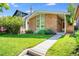 Charming brick home with a well-manicured lawn and colorful flowers enhancing the curb appeal at 1622 Monroe St, Denver, CO 80206
