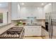 Kitchen featuring white cabinets, granite counters, stainless steel appliances, and natural light at 1622 Monroe St, Denver, CO 80206