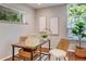 Bright office space with natural light, wooden desk, and views of lush greenery outside the windows at 1622 Monroe St, Denver, CO 80206