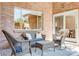 Cozy brick patio with wicker furniture, outdoor rug, and view from sliding door at 1622 Monroe St, Denver, CO 80206