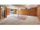 Spacious basement with wood paneling, carpet flooring and sliding glass door at 1720 S Balsam St, Lakewood, CO 80232