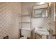 A bathroom including a vanity and toilet, with wallpaper at 1720 S Balsam St, Lakewood, CO 80232