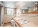 Retro bathroom featuring tiled walls and floors, a unique window, and vanity, ready to be enjoyed or updated at 3900 Garland St, Wheat Ridge, CO 80033