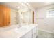 Well-lit bathroom with a double sink vanity, tiled shower, and ample storage space for a functional and clean design at 3900 Garland St, Wheat Ridge, CO 80033