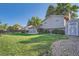 A well-manicured backyard features lush green lawn, beautiful landscaping, wooden fence, and a storage shed at 4664 S Zang St, Morrison, CO 80465