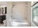 Bright bathroom features a bathtub with shower head and decorative shelves at 4664 S Zang St, Morrison, CO 80465