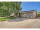 Exterior view with a large tree, two car garage, driveway and well-maintained landscaping at 4664 S Zang St, Morrison, CO 80465