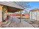 Back patio with stone walkway, garden beds, covered seating, and fenced yard at 4499 E Colorado Ave, Denver, CO 80222