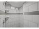 Shower stall featuring a shower head, tiled walls and recessed shelf at 4499 E Colorado Ave, Denver, CO 80222