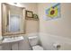Cozy half bath featuring a pedestal sink, beadboard walls, and charming decor at 9889 Aftonwood St, Highlands Ranch, CO 80126