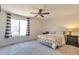 Comfortable bedroom with large window, ceiling fan, neutral carpet, and modern furnishings at 9889 Aftonwood St, Highlands Ranch, CO 80126