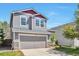 Charming two-story home featuring gray siding, a gray garage door, stone accents, and a well-manicured lawn at 9889 Aftonwood St, Highlands Ranch, CO 80126