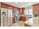 Beautiful kitchen featuring stainless steel appliances, cherry cabinets, gray backsplash, and granite countertops at 9889 Aftonwood St, Highlands Ranch, CO 80126