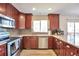 Well-lit kitchen featuring cherry cabinets, stainless steel appliances, gray backsplash, and great counter space at 9889 Aftonwood St, Highlands Ranch, CO 80126