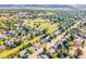 Wide aerial view of a neighborhood including a home, nearby Trappers Glen Park and mature trees at 12234 W Saratoga Ave, Morrison, CO 80465
