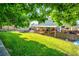Spacious backyard featuring a lush lawn, wooden deck, trampoline and shade trees at 12234 W Saratoga Ave, Morrison, CO 80465
