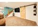 Finished basement includes a sliding barn door, staircase, and plush carpet at 12234 W Saratoga Ave, Morrison, CO 80465