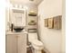 Powder room featuring a vessel sink, decorative mirror, and sleek black fixtures at 12234 W Saratoga Ave, Morrison, CO 80465