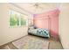 Cozy bedroom features a four-post bed, plush rug, and fun pink accent wall and ceiling at 12234 W Saratoga Ave, Morrison, CO 80465
